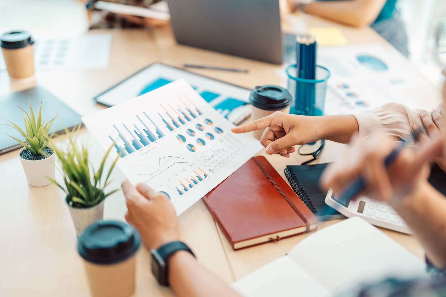 Equipe analisando gráficos e dados de pesquisa de mercado em reunião